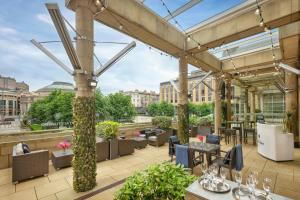 a patio with tables and chairs and a view of a city at Sheraton Grand Hotel & Spa in Edinburgh