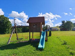 a playground with a house and a slide at Domki na Ostrysie in Ciche