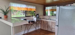 a kitchen with a sink and a refrigerator at Bosque Alto Lodge in Platanal