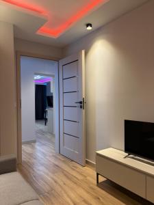 a room with a living room with a tv and a door at MAX Apartaments in Częstochowa
