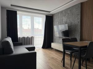 a living room with a dining room table and a television at MAX Apartaments in Częstochowa