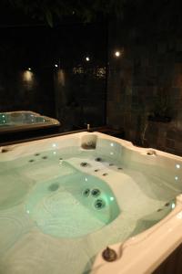 a jacuzzi tub in a bathroom at night at Apartman Spa Zelena dolina in Kragujevac