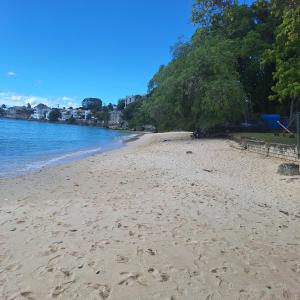 a beach with footprints in the sand and the water at 205 Batts Rock Beach Condos in Saint Michael
