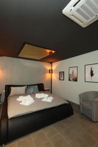 a bedroom with a bed with towels on it at Apartman Spa Zelena dolina in Kragujevac +13 photos