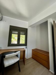a room with a chair and a desk and a window at Tsonas Maisonette in Lygia