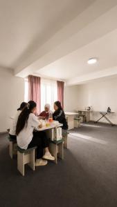 a group of women sitting at a table in a room at Золотые пески in Bosteri