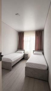 a bedroom with two beds and a window at Золотые пески in Bosteri