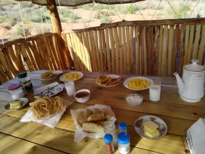 a wooden table with food and drinks on it at Mars Canyon Yurt Camp in Tong