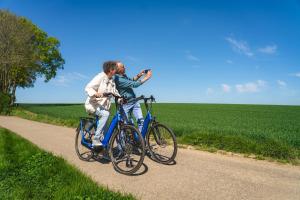 two men riding bikes on a dirt road at Group accommodation 123 in Valkenburg