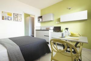 a bedroom with a bed and a table and a kitchen at Studio 2- lake view in Oggebbio