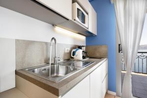 a kitchen with a stainless steel sink and a window at Studio 2- lake view in Oggebbio