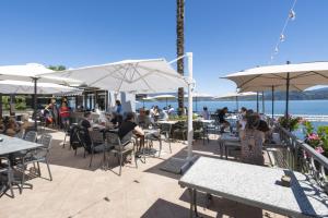 people sitting at tables and umbrellas at a restaurant at Studio 2- lake view in Oggebbio +4 photos