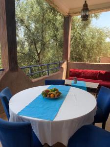 a table with a bowl of fruit on top of it at Riad Belgika Marrakech in Ourika