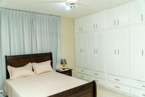 a bedroom with white cabinets and a bed at bohiostay in Azua