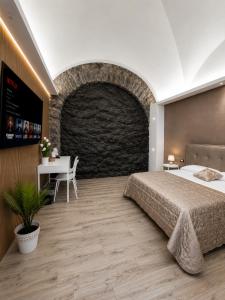 a bedroom with a large bed and a brick wall at Il Casale del 900 in Catania