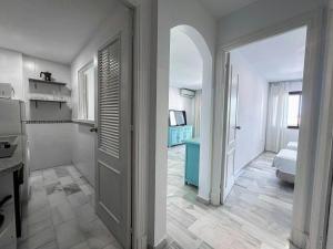 a white room with a door and a bathroom at Vistahermosa Gestur Apartamentos in El Puerto de Santa María