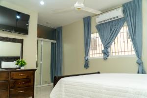 a bedroom with a bed and a dresser and a window at bohiostay in Azua