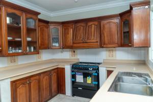 a kitchen with wooden cabinets and a stove top oven at bohiostay in Azua +5 photos