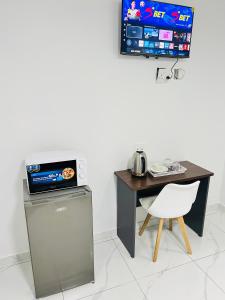 a small table and a desk with a computer and a chair at Botha Villa Lodge Goodwood in Cape Town
