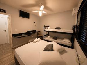 a bedroom with two beds and a ceiling fan at Suítes Modernas com Ar-Condicionado e Estacionamento in Hortolândia