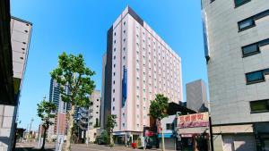 a tall white building on a city street at Holiday Inn Express Sapporo Susukino by IHG in Sapporo