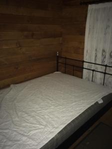 a bed in a room with a wooden wall at Sarakina Wooden House in Elaiokhórion