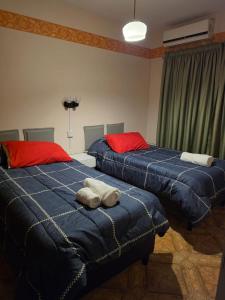 two beds sitting next to each other in a bedroom at Casa del centro in San Martín