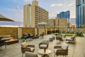 a patio with chairs and tables on a rooftop with buildings at Sheraton Philadelphia University City Hotel in Philadelphia