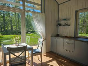 a kitchen with a table and chairs and a window at Väänavilla Romantic Getaway in Vääna-Jõesuu