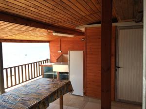 a kitchen with a refrigerator and a table on a balcony at Sarakina Wooden House in Elaiokhórion