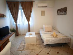 a small room with a bed and a tv at Apartman Ivona in Zadar