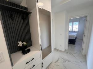 a white room with a mirror and a bedroom at Sea you in Bar in Bjeliši