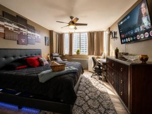a bedroom with a bed and a flat screen tv at Beautiful 3BR Condo in DTWN Pool Access in Atlanta