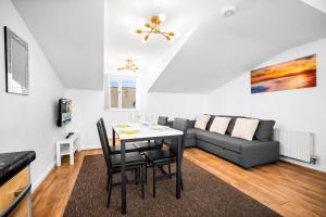 a living room with a table and a couch at Providence Suites 1 Bedroom Sleeps 4 Perfect for Contractors and Families and Solo Travellers in Fallings Park