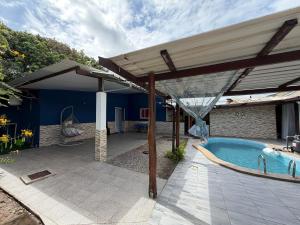 a patio with an umbrella and a swimming pool at La Villa La ri Deye in Kourou