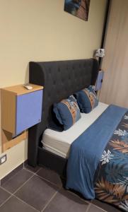a bed with a black headboard and a night stand at La Villa La ri Deye in Kourou