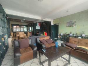 a living room with leather couches and a table at Hostal Santa Anna in Xalapa