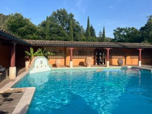 a large swimming pool in front of a house at L'Hacienda in Mialet