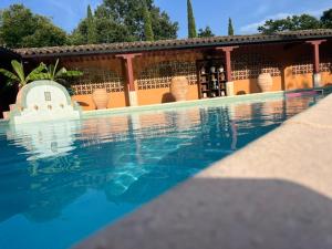 a swimming pool in front of a house at L'Hacienda in Mialet