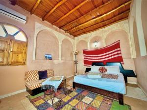 a bedroom with a bed and a couch in a room at Riad Belgika Marrakech in Ourika