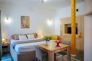 a hotel room with a bed and a table and a kitchen at Infinity Apartman in Esztergom
