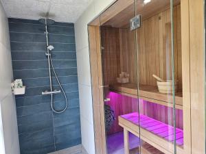 a bathroom with a glass shower with purple accents at Väänavilla Romantic Getaway in Vääna-Jõesuu +7 photos