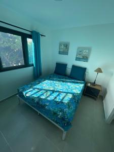 a bed in a room with a window at Blue sunset - Appartement avec vue mer in Papeete