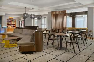 a restaurant with tables and chairs and a couch at Springhill Suites by Marriott Detroit Metro Airport Romulus in Romulus