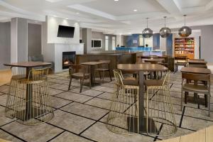 a restaurant with tables and chairs and a fireplace at Springhill Suites by Marriott Detroit Metro Airport Romulus in Romulus