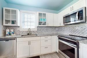 a white kitchen with white cabinets and appliances at East Nashville Discovery in Nashville