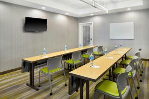 a conference room with tables and chairs and a flat screen tv at Springhill Suites by Marriott Detroit Metro Airport Romulus in Romulus