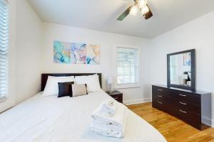 a white bedroom with a bed and a ceiling fan at East Nashville Discovery in Nashville