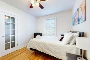 a white bedroom with a bed and a ceiling fan at East Nashville Discovery in Nashville +9 photos