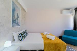 a bedroom with a white bed and a blue couch at GuestReady - Tranquil Oasis in Lagoa in Lagoa